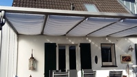 Glasdach mit Sonnensegeln in Seilspanntechnik 